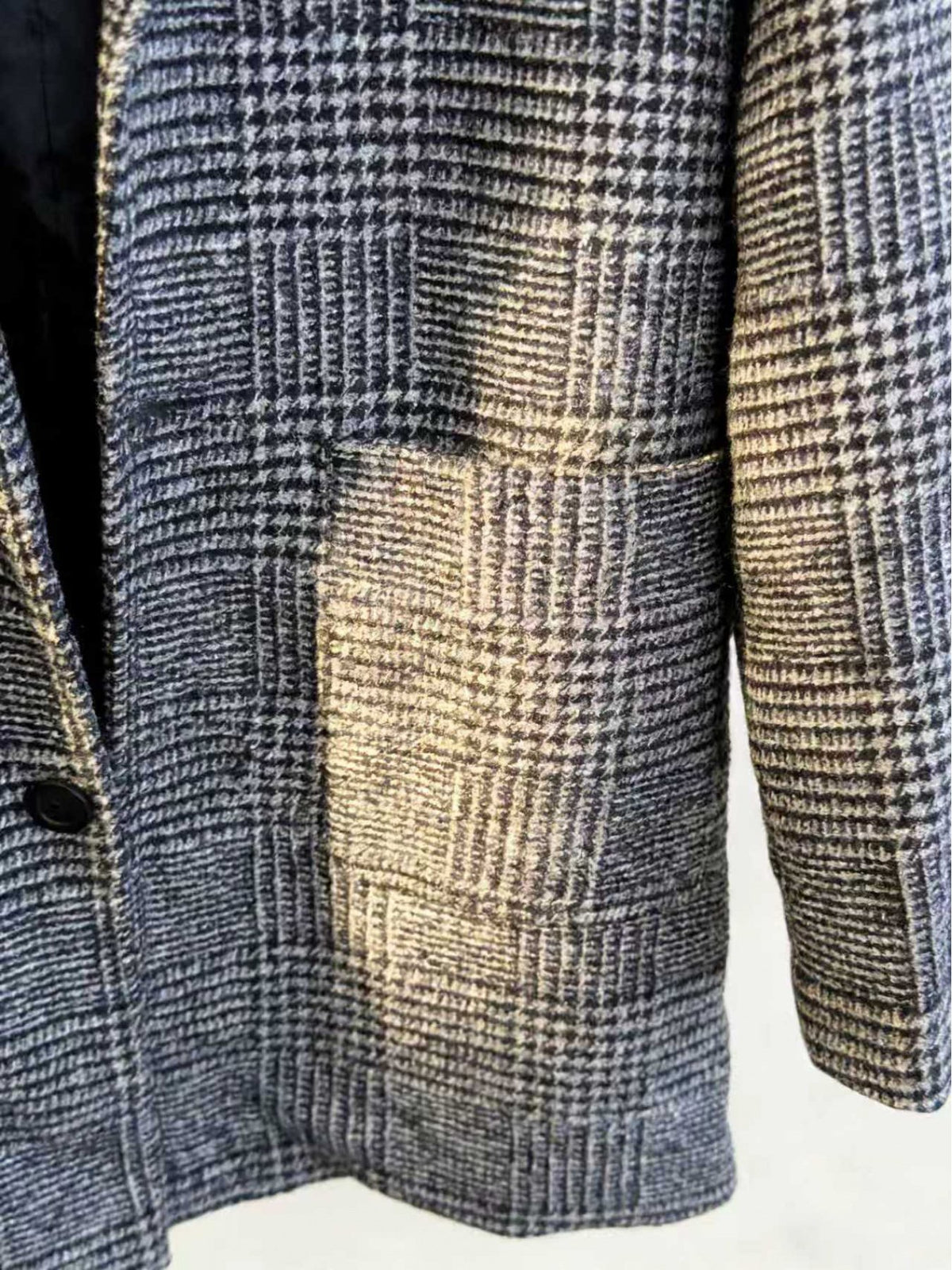 Close-up of the men's houndstooth check coat fabric and stitching
