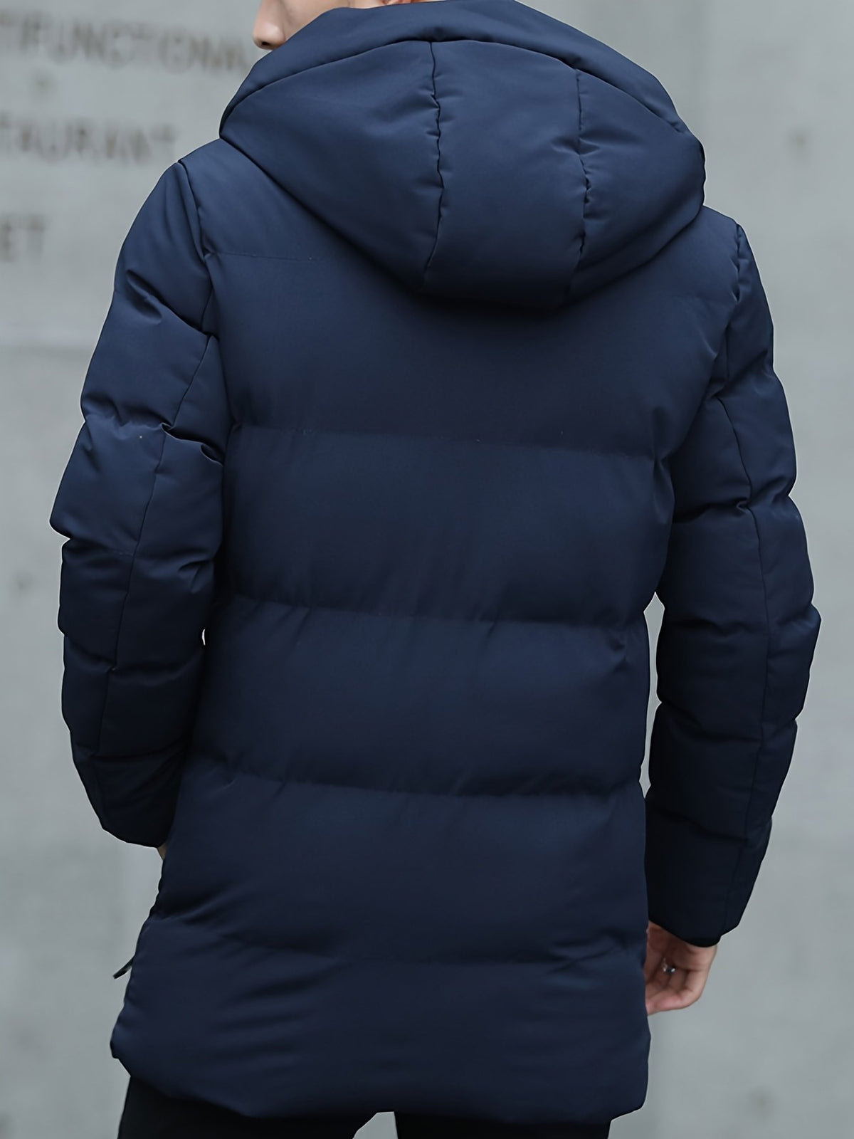 Men's mid-length padded parka styled with jeans for cold weather