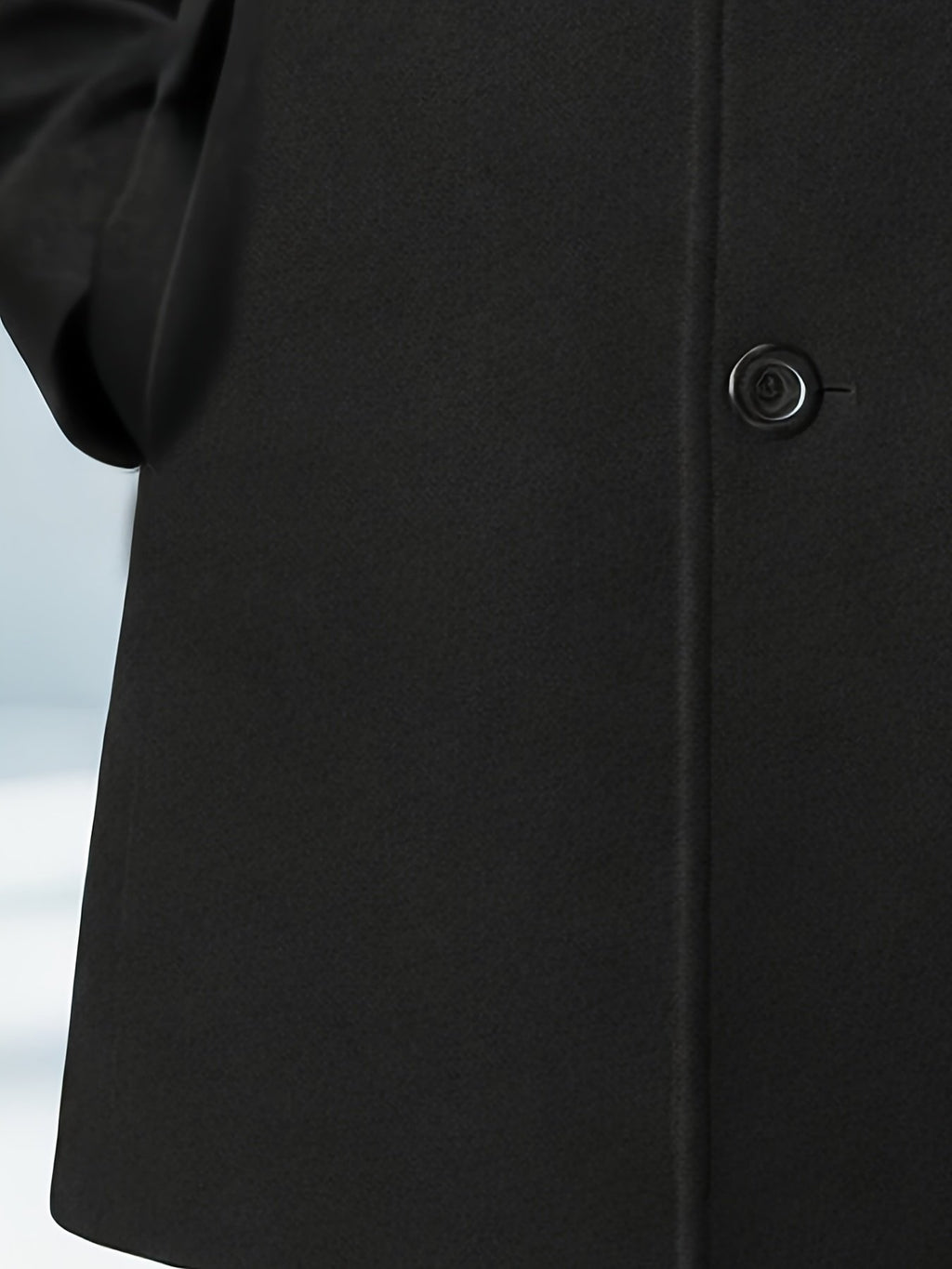Collar and fastening detail of the men's black trench coat