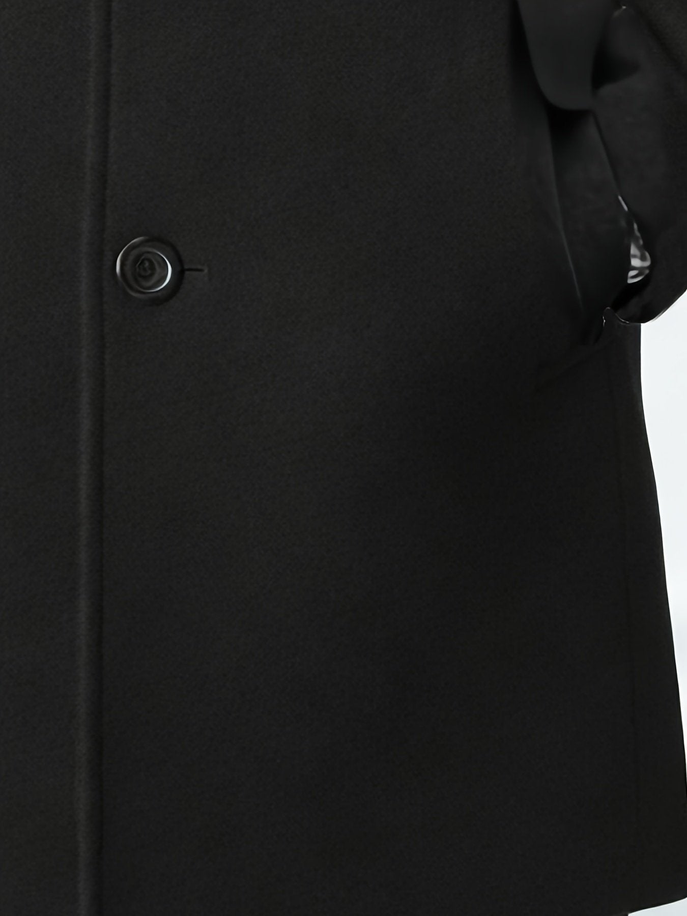 Men's black trench coat styled with jeans for cold weather